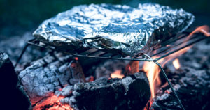 Papillotes d'aluminium sur la flamme d'un Bbq