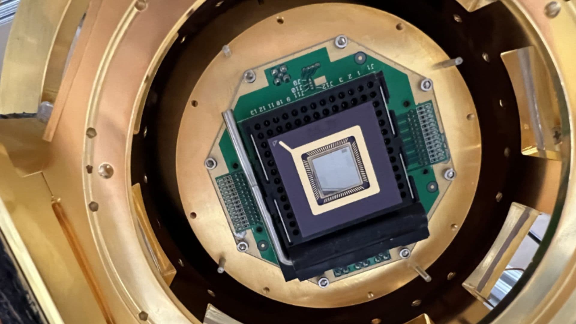 Vue rapprochée d’une puce quantique supraconductrice installée dans un dispositif cryogénique.